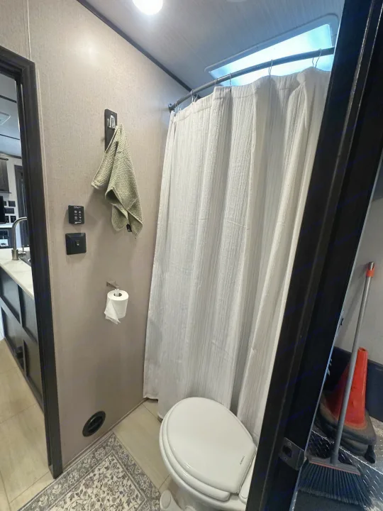 Compact RV rental bathroom with toilet, shower, and sink area. Essential amenities for comfortable travel.. Forest River X-Lite 2017