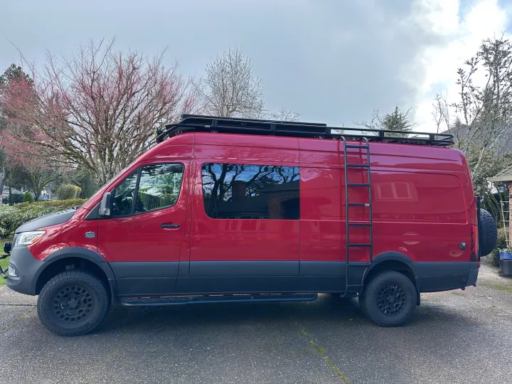 Red custom Sprinter van, perfect for your next rv rental adventure. Features roof rack, ladder, and off-road tires.. Mercedes Sprinter 2022