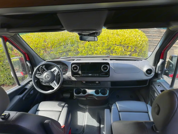 Spacious Mercedes Sprinter rv rental interior, showing dashboard, steering wheel, and front seats from a rear view.. Mercedes Sprinter 2022