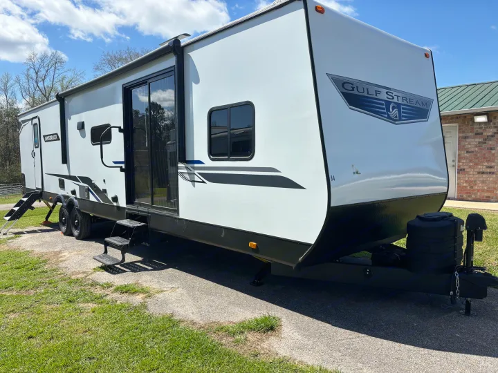 White Gulf Stream Innsbruck travel trailer, available for rv rental, parked on a paved lot on a sunny day.. Gulf Stream Innsbruck 2024