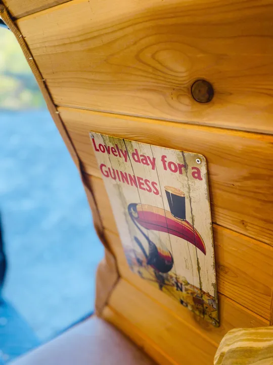 Cozy RV rental interior with wooden paneling and a fun "Guinness" sign featuring a toucan.. Ford Econolline 250s 2001