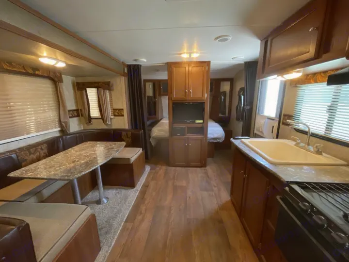 Spacious rv rental interior features a kitchen, dining booth, and rear bedroom.. Keystone RV Bullet Ultra Lite 2014