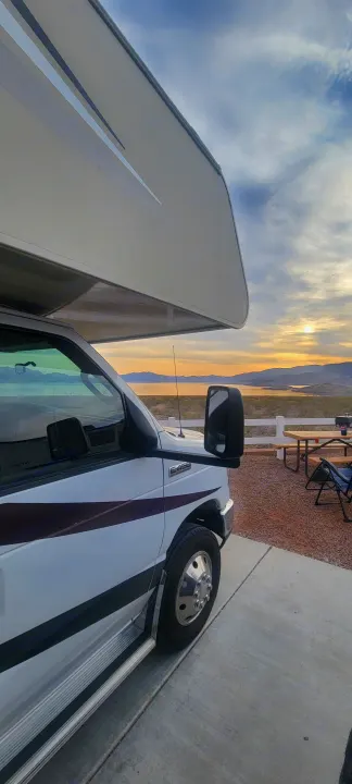 Scenic rv rental view: Class C RV parked by a lake at sunset. Perfect spot for nature and relaxation!. Forest River Coachmen Leprechaun 2018