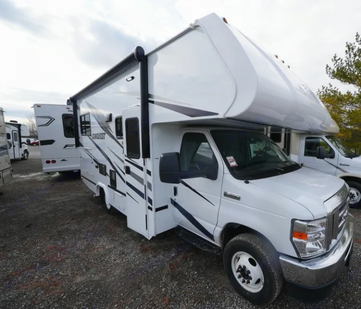 White Class C RV with extended awning, perfect for an rv rental adventure, parked outdoors.. Gulf Stream Conquest 2023