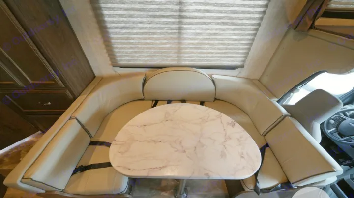 Cozy RV rental interior features a spacious U-shaped dinette with a modern marble table. Ideal for family travel.. Gulf Stream Conquest 2023