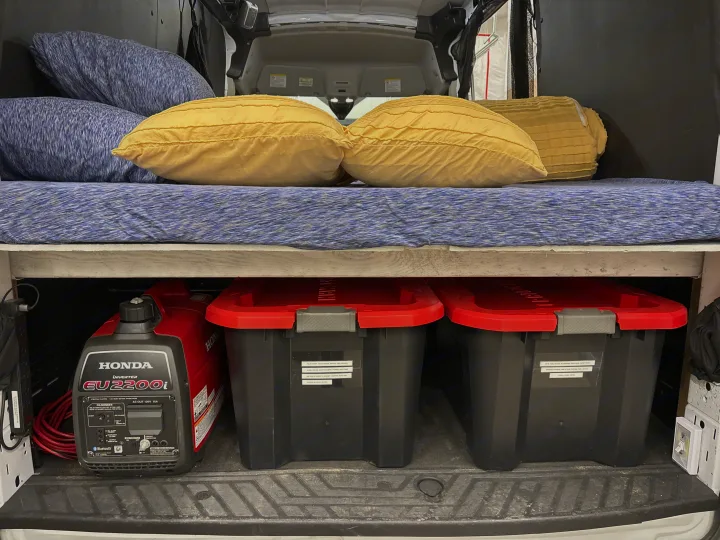 RV rental: Honda EU2200i generator and organized bins under a comfy bed, ideal for van life camping.. Ford Transit 2023