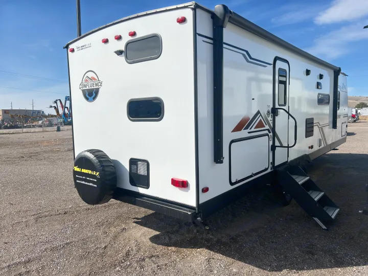 White Confluence travel trailer available for RV rental, showing rear spare tire and side entry steps.. KZ Confluence 2022