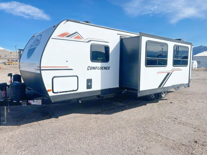 View of a white Confluence travel trailer with an extended slide-out, ideal for your next rv rental adventure.. KZ Confluence 2022