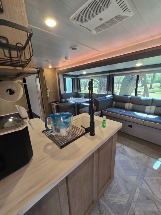 Spacious RV rental interior with modern kitchen, living area, and scenic views outside.. Forest River Salem Platinum 2024