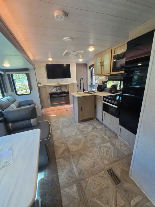 Bright rv rental interior featuring a modern kitchen, cozy living room with TV & fireplace. Spacious & well-equipped.. Forest River Salem Platinum 2024