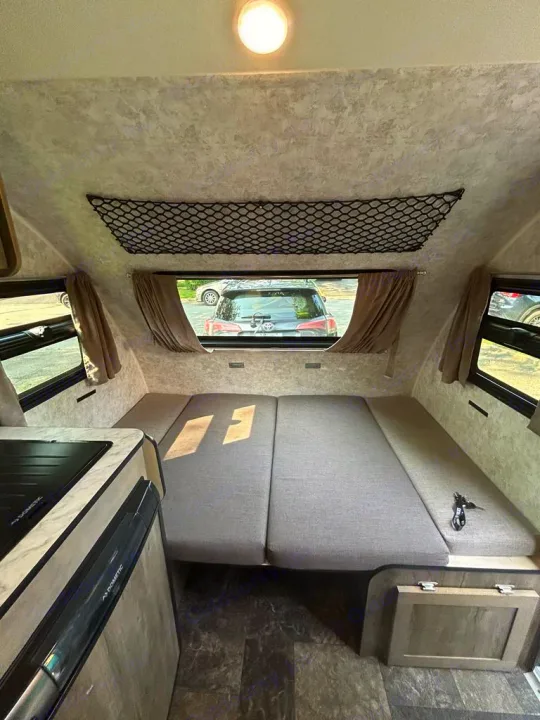 This rv rental offers a versatile interior with a convertible bed/seating area, compact kitchen, and overhead storage.. Prolite Prolite Trailer 2022