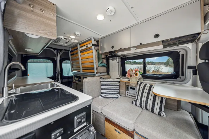 Inside a modern **RV rental**: well-equipped kitchen, plush seating, and a beautiful waterside vista for your journey.. Winnebago Solis Pocket 2022
