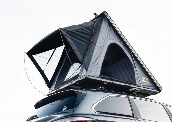 A dark gray SUV features an open San Hima rooftop tent setup. Perfect for an RV rental adventure.. Toyota Other 2025