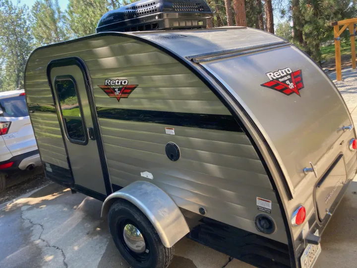 This compact, beige Retro Jr. travel trailer with Dometic AC is ready for your RV rental outdoor adventure.. Riverside RV Retro 2017