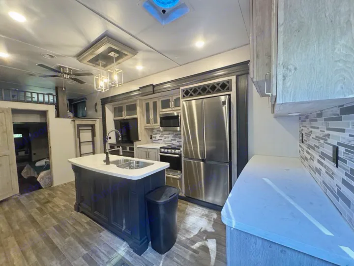 Step into this modern RV rental! Features a spacious kitchen island, full-size fridge, ceiling fan, and loft. Ideal for your next trip.. Keystone RV Avalanche 2022