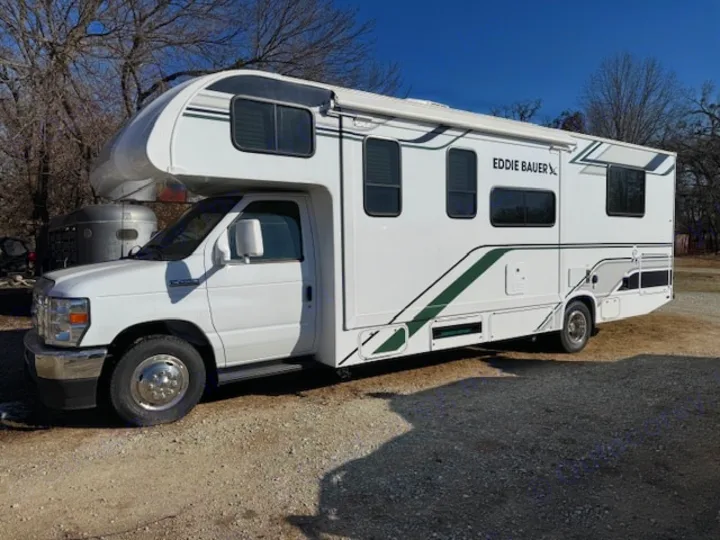 Pristine white Eddie Bauer Class C RV for your next rv rental adventure, parked on gravel under clear skies.. Thor Eddie Bauer 28EB 2025