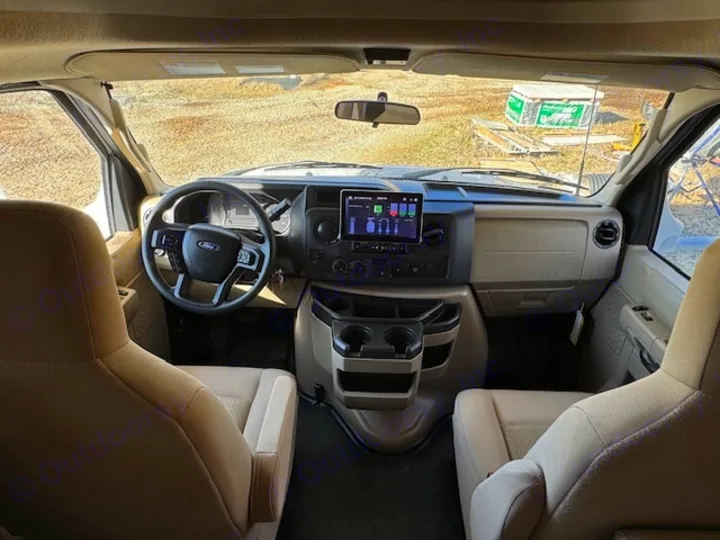 Inside an rv rental: spacious front cockpit with a Ford steering wheel, dashboard controls, and comfortable driver/passenger seats.. Thor Eddie Bauer 28EB 2025