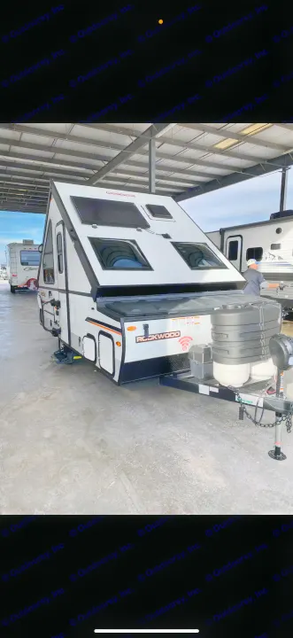 White Rockwood A-frame pop-up camper, parked under cover, ready for rv rental adventures.. Forest River Rockwood LTD 2023