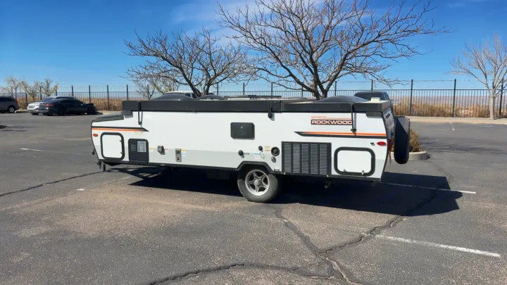 White Rockwood pop-up RV rental, a compact travel trailer, ready for adventure in a sunny paved lot.. Forest River Rockwood LTD 2023