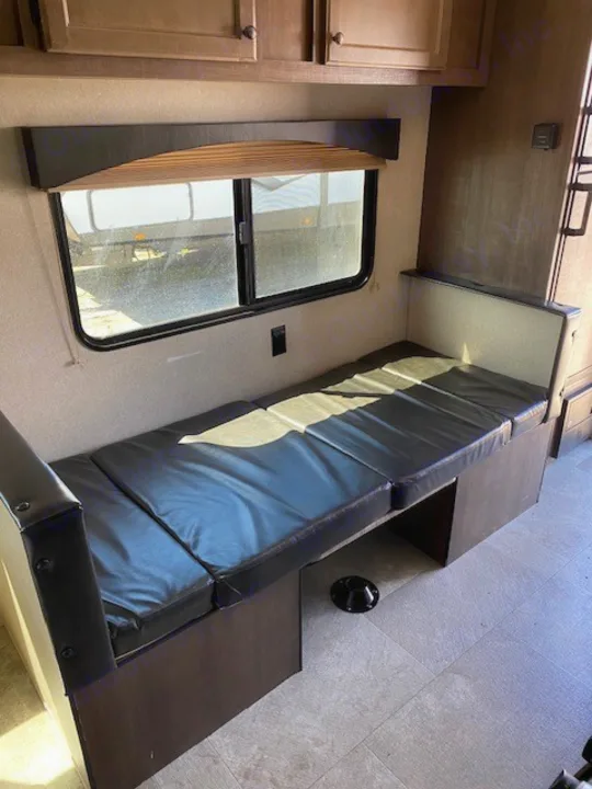 RV rental interior: Dinette converts to bed with window, cabinets. Table base for travel adventures.. Sunset Park RV Sun Lite 2021