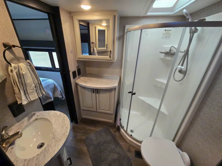 RV rental: A bright, well-appointed bathroom with vanity sink, mirror, compact shower, and toilet for comfortable travel.. Open Range Highland Ridge 2021