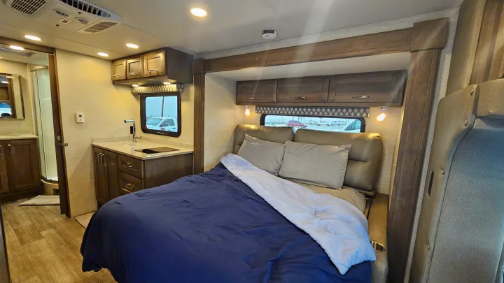 Modern rv rental interior showcasing a comfortable bed, functional kitchen, and integrated bathroom for convenient travel.. Tiffin Motorhomes Allegro Midas 24MT 2024