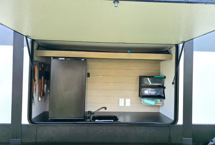 Functional RV rental outdoor kitchen featuring a fridge, sink, and organized storage for all your camping needs.. Forest River Salem Platinum 2024