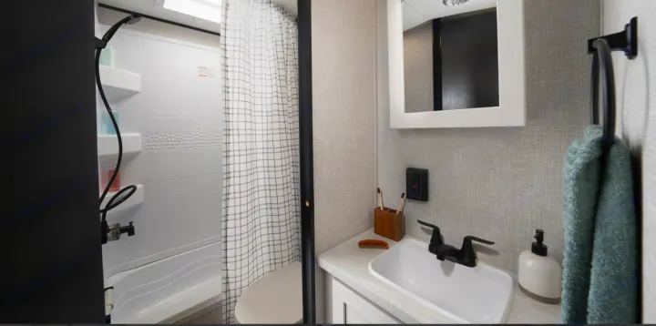 Spacious RV rental bathroom featuring a shower/tub combo, toilet, and vanity with sink & mirror.. Jayco Jay Flight 261BHS 2025