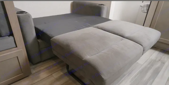 Comfortable RV rental interior: Modern gray sofa converts to bed with cup holder, on wood-look flooring.. Jayco Jay Flight 261BHS 2025