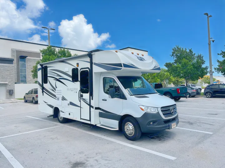 White Jayco Melbourne Class C RV rental parked in a lot under a clear blue sky.. Jayco Melbourne 2020