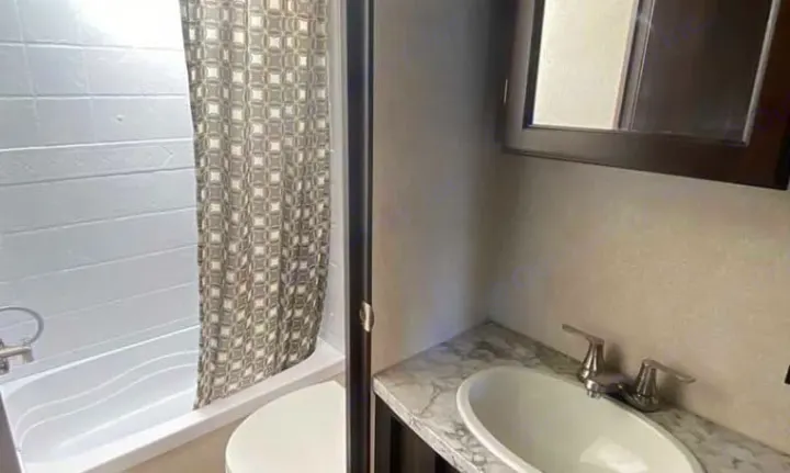 RV rental bathroom features: compact shower with patterned curtain and a vanity with sink and mirror.. Jayco Jay Flight 2019