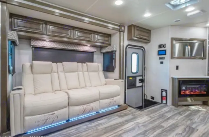 Stylish rv rental interior showcasing a comfortable recliner couch with LED lighting and a built-in electric fireplace.. Georgetown GT7 2022