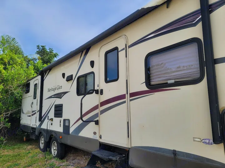 A large, tan Heritage Glen travel trailer (RV rental) with an extended awning, parked outdoors.. Forest River Wildwood Heritage Glen Lite 2014