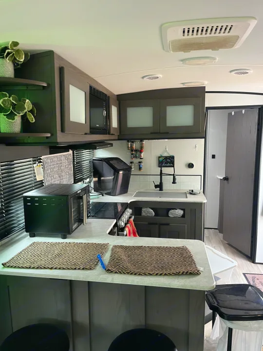 Compact modern RV rental kitchen. Features include microwave, toaster oven, sink, and ample storage for comfortable travels.. Cruiser RV MPG 2022