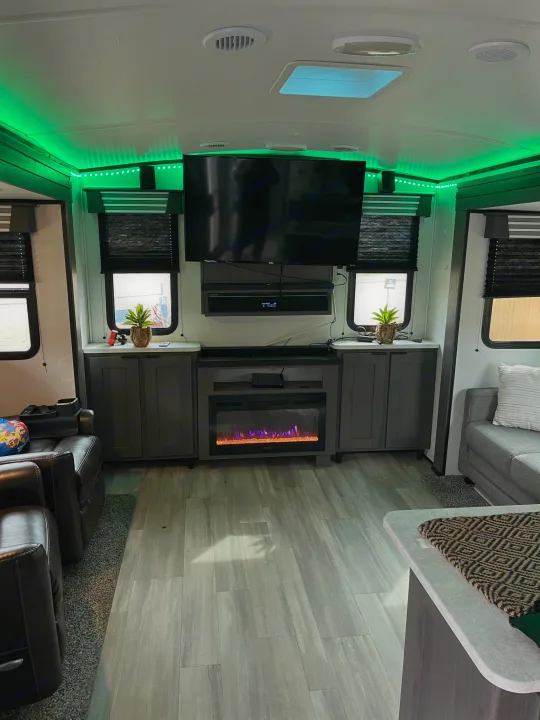 Step inside this RV rental's well-appointed living area, complete with a TV, electric fireplace, and stylish green LEDs.. Cruiser RV MPG 2022