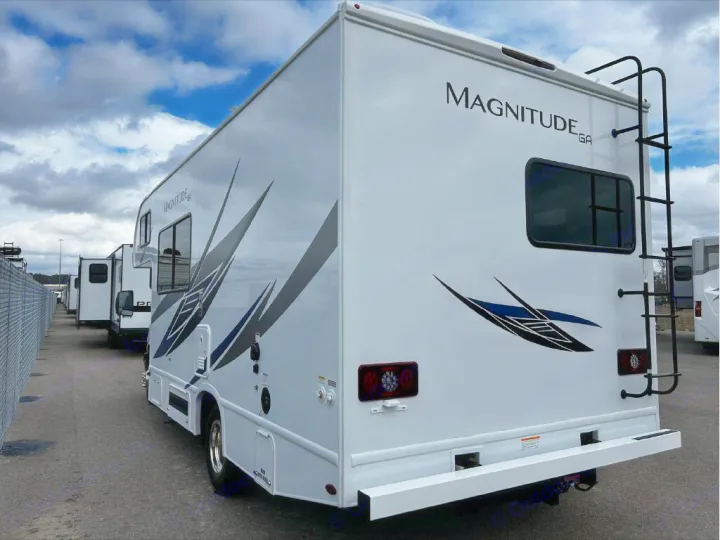 White Magnitude GA RV rental parked outdoors, showcasing its modern graphics, rear ladder, and bumper. Ready for travel.. GMC/THOR MAGNITUDE 2025