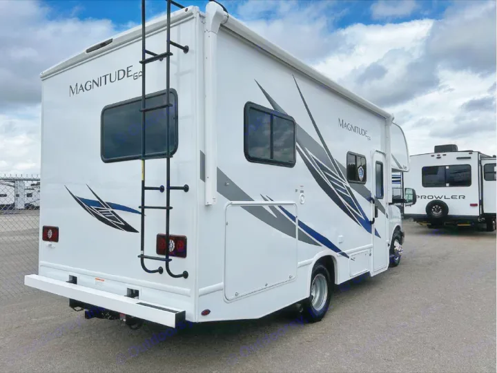 This white Class C RV with "Magnitude GA" branding is ready for an rv rental adventure. Parked outdoors on a cloudy day.. GMC/THOR MAGNITUDE 2025