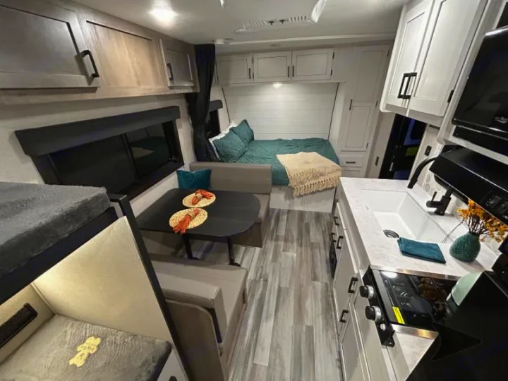 Modern rv rental interior: bunk beds, kitchen, and dinette with a main bed at the rear. Ready for your adventure!. Other Other 2025