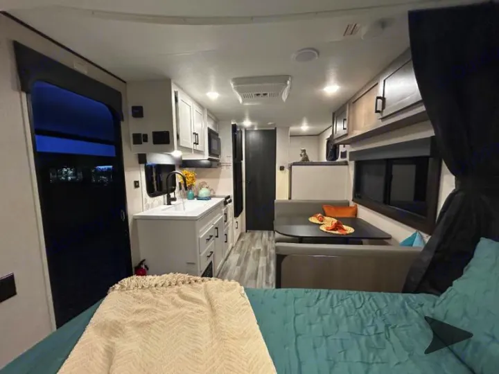 Explore this bright, well-appointed rv rental interior featuring a kitchen, dinette, and cozy sleeping area.. Other Other 2025