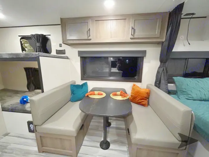 Comfortable RV rental interior: dinette, bunk beds, and a main sleeping area. Perfect for family adventures.. Other Other 2025