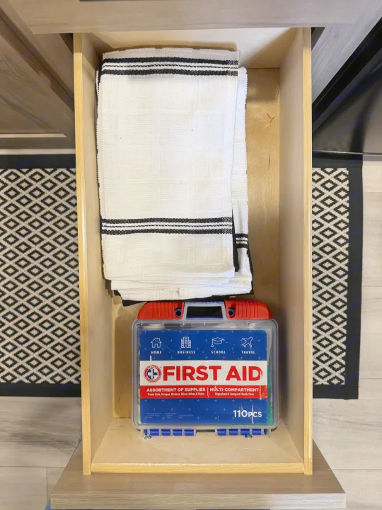 RV rental drawer: folded towels and a 110-piece multi-purpose first aid kit, ready for home or travel.. Keystone RV Coleman 13B 2025