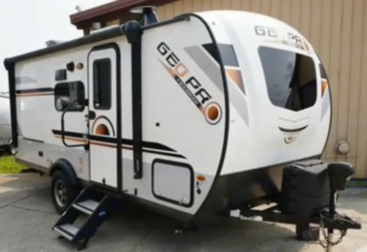 This white and gray Geo Pro travel trailer, perfect for an RV rental adventure, is shown parked outside.. Geopro 19Bh 2021