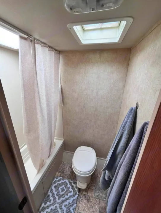 RV rental bathroom: small shower/tub, toilet, and overhead vent/skylight.. Forest River Salem Cruise Lite 2013