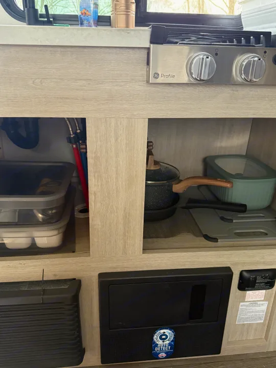 Efficient RV kitchen, storage, and utility panel in an **rv rental**. Includes GE Profile cooktop & safety detector.. Forest River Coachmen Catalina Summit 2024