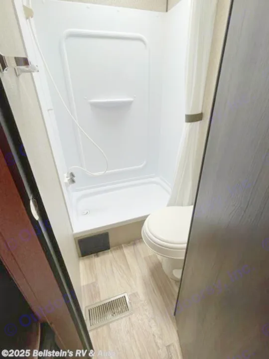 This RV rental bathroom features a compact white shower, toilet, and light wood-look flooring.. Keystone RV Springdale 2019