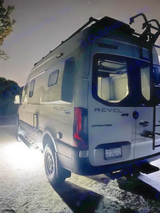 White Winnebago Revel 4x4 RV lit at night, perfect for an rv rental adventure.. Winnebago Revel 2024