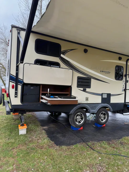 Set up your RV rental: Travel trailer with extended awning, outdoor kitchen, and leveling blocks.. Keystone RV Bullet Ultra Lite 2017