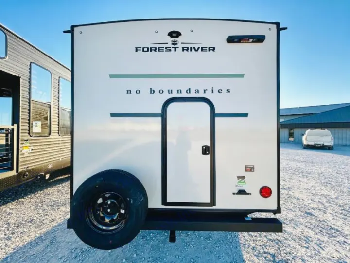 Rear view of a white Forest River No Boundaries travel trailer with a spare tire, ready for an RV rental.. Forest River No Boundaries NoBo 20.3 2025