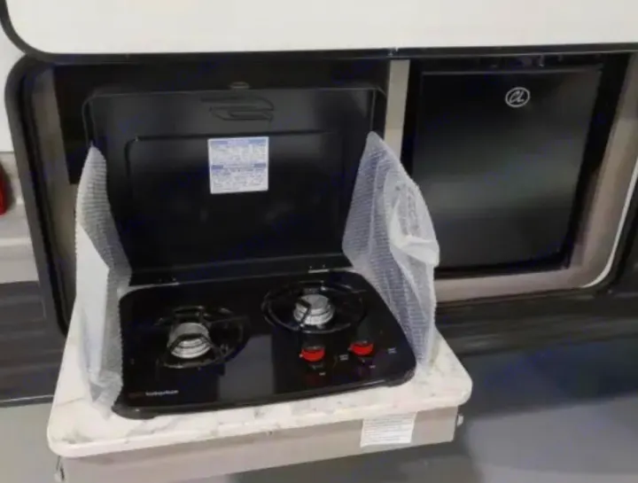 This RV rental offers a practical outdoor kitchen: a two-burner stove and compact refrigerator.. Dutchmen Coleman Lantern LT 2021