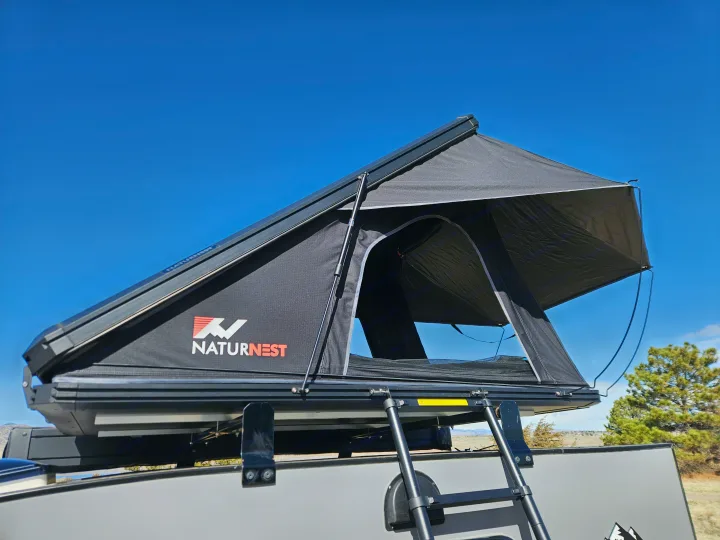 Black NaturNest rooftop tent deployed on an RV rental, with a ladder for easy access. Ready for outdoor camping.. Escapade Ridge 2018